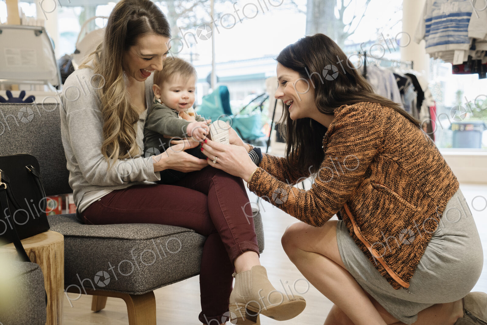Caucasian women and baby boy shopping in shoe store
