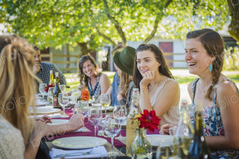 Caucasian women talking at table at party outdoors