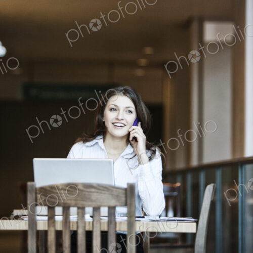 Caucasiasn business woman on the phone in a coffee shop. Caucasiasn business woman on the phone in a coffee shop.