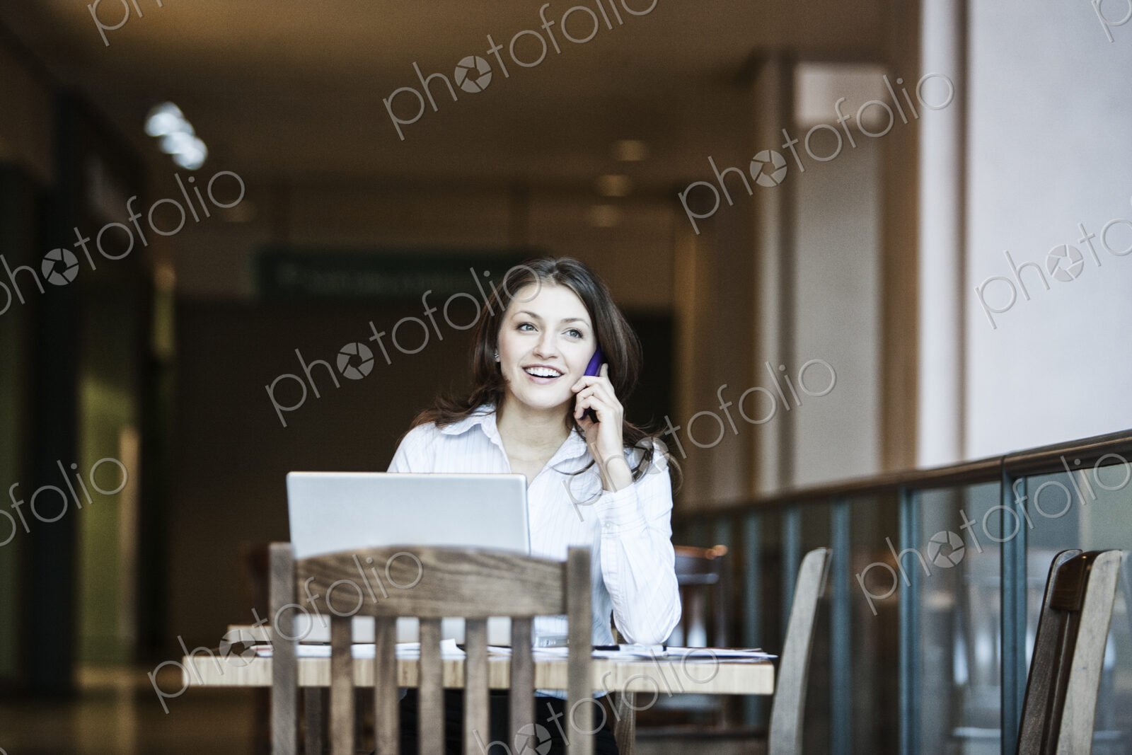 Caucasian business woman on the phone in a coffee shop.