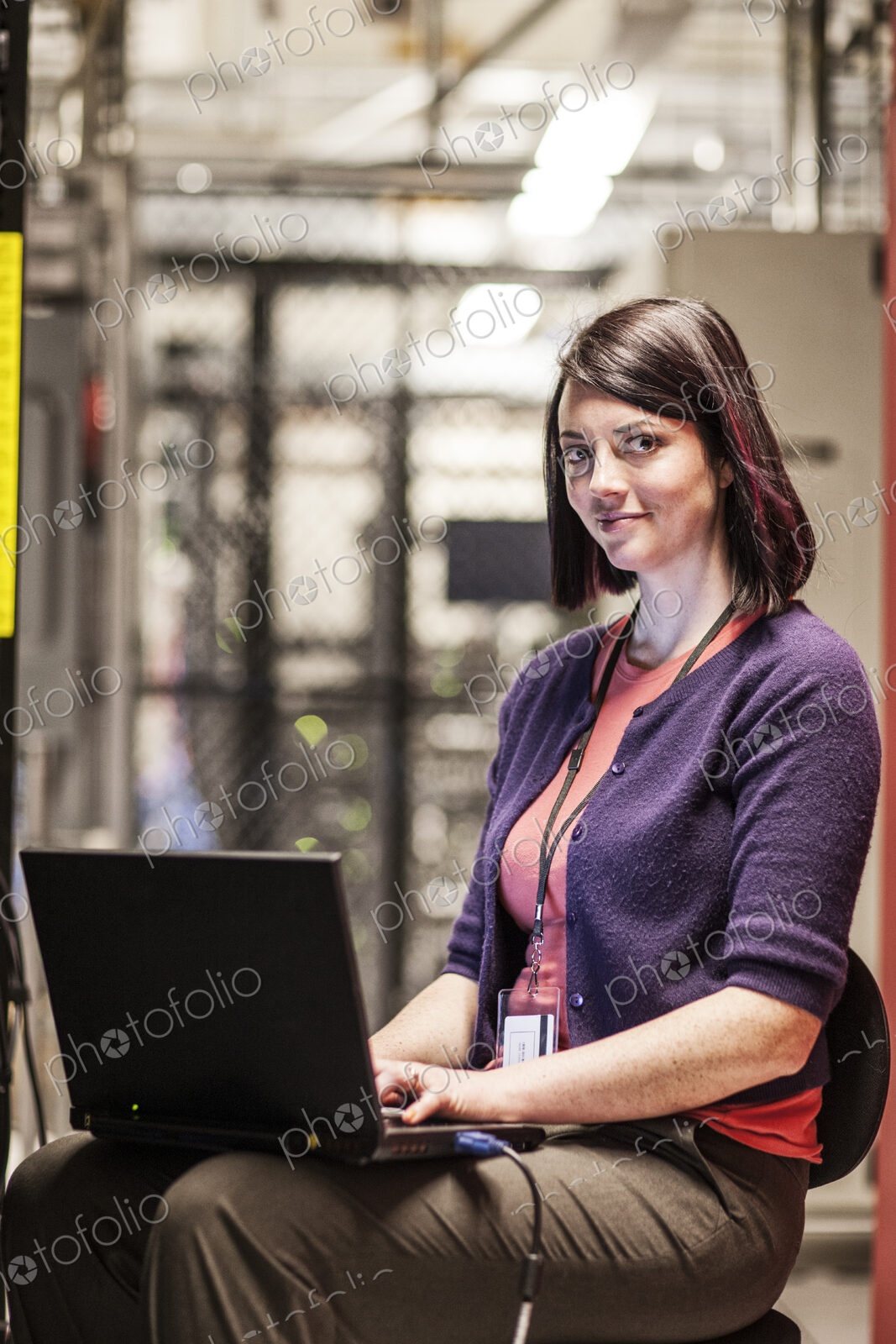 Caucasian woman technician working in a large computer server farm.