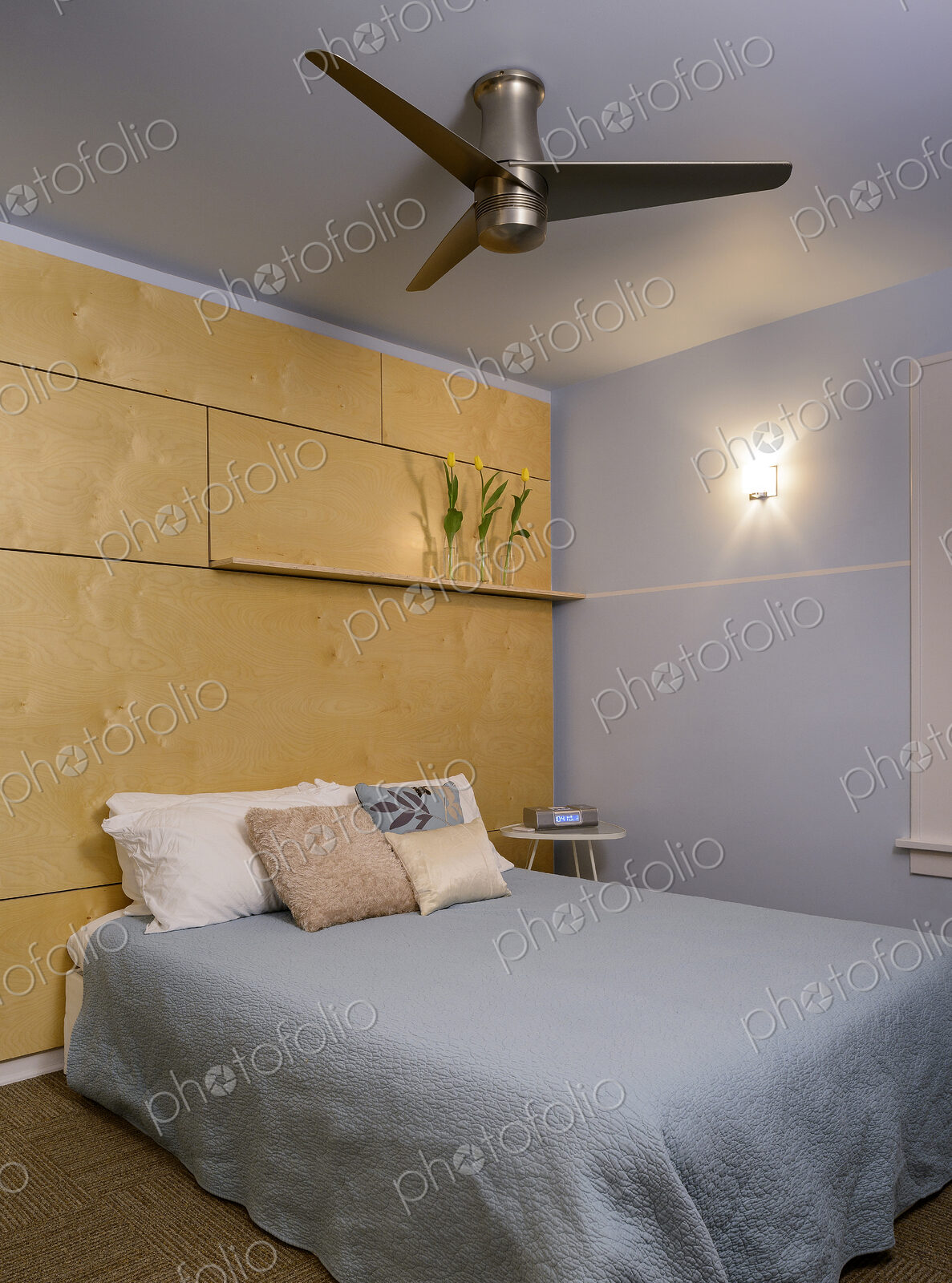Ceiling fan and bed in modern bedroom