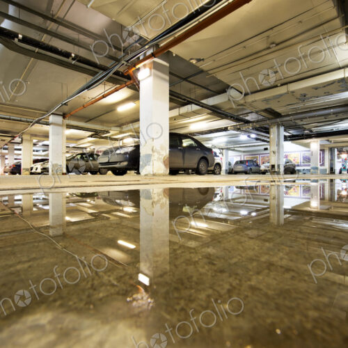 Ceiling reflected in wet parking structure floor Ceiling reflected in wet parking structure floor