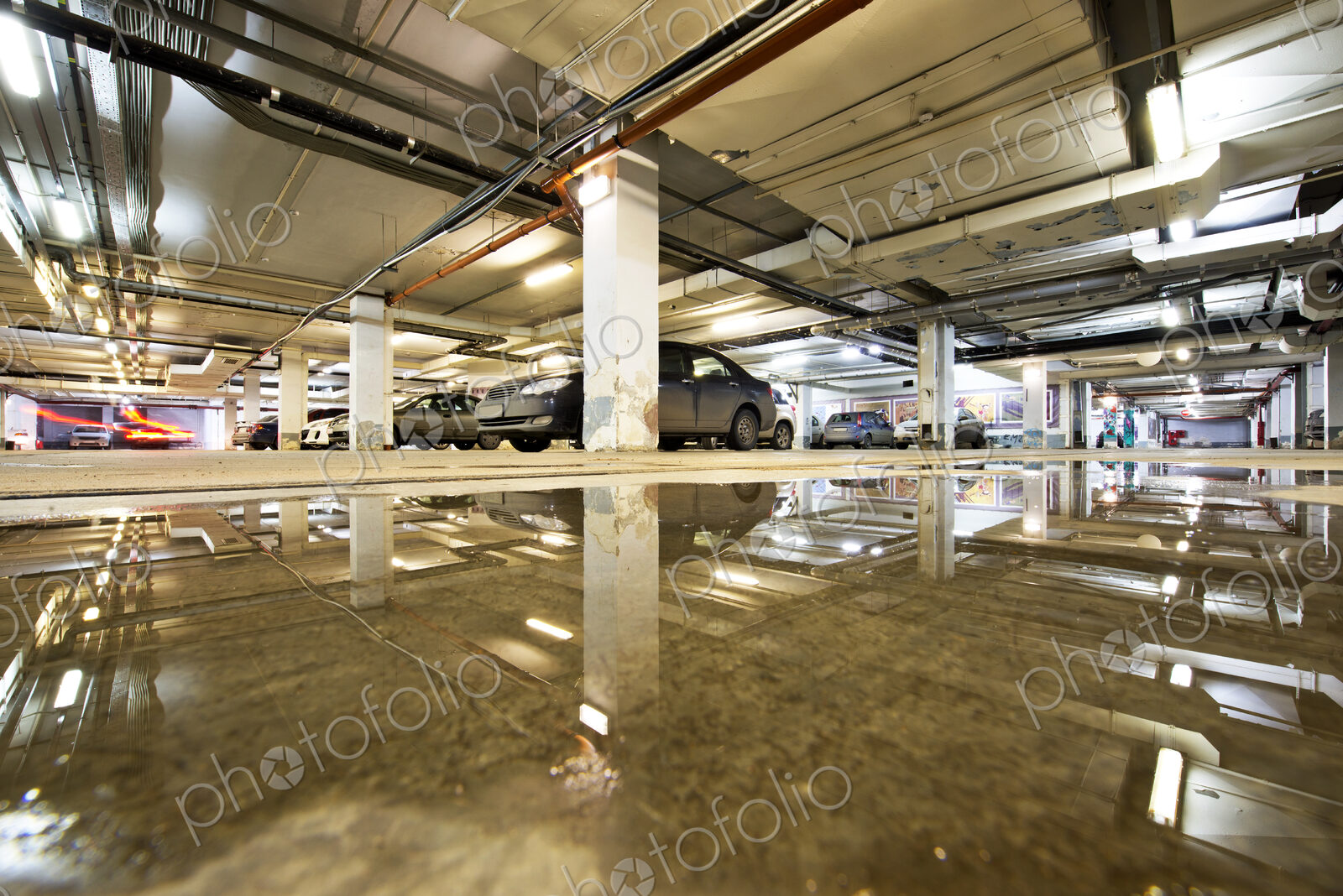 Ceiling reflected in wet parking structure floor