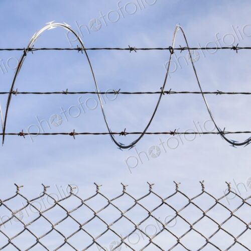 Chain link fence topped with barbed and razor wire, Portland, Oregon, USA Chain link fence topped with barbed and razor wire, Portland, Oregon, USA