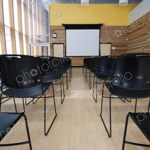 Chairs and projection screen in empty room