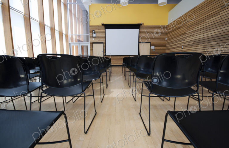 Chairs and projection screen in empty room