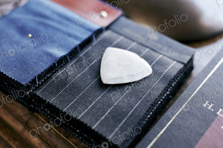 Chalk resting on cloth material samples used for making handmade suits