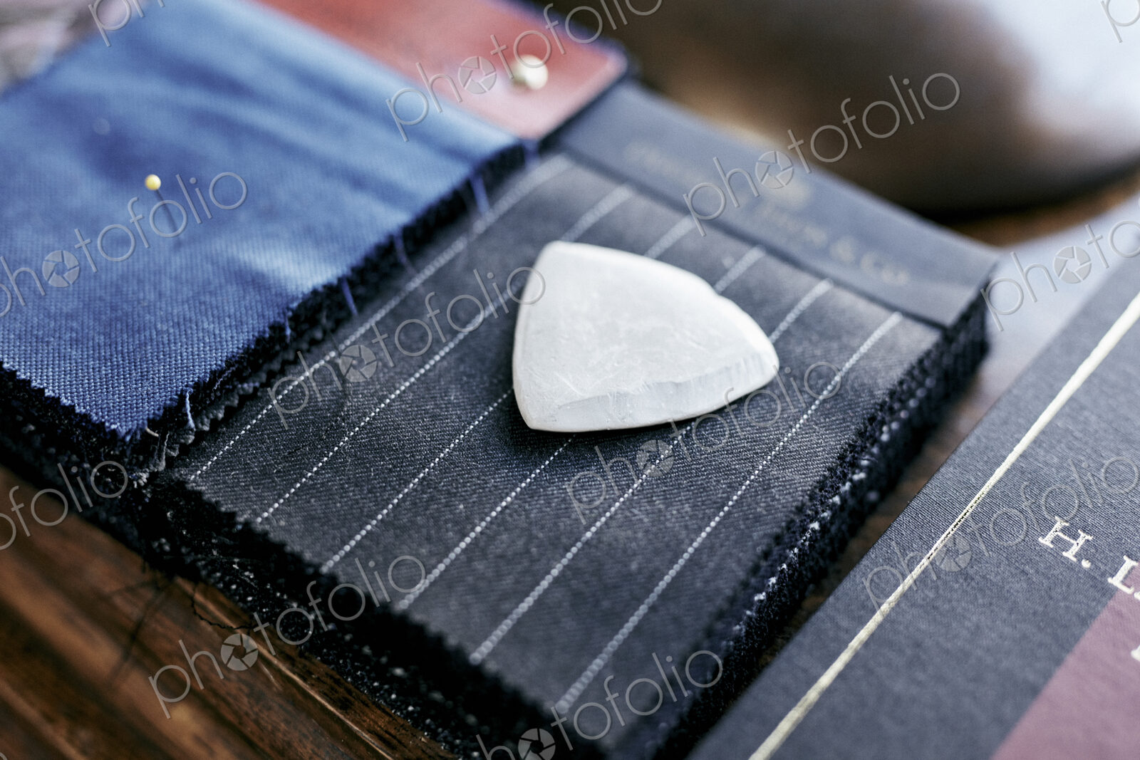 Chalk resting on cloth material samples used for making handmade suits
