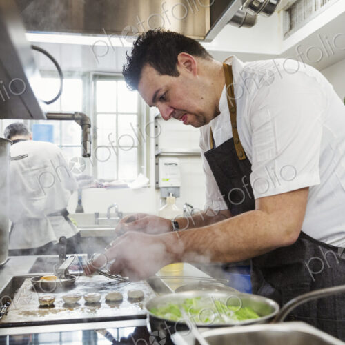 Chef cooking in the kitchen of a small boutique hotel. Chef cooking in the kitchen of a small boutique hotel.