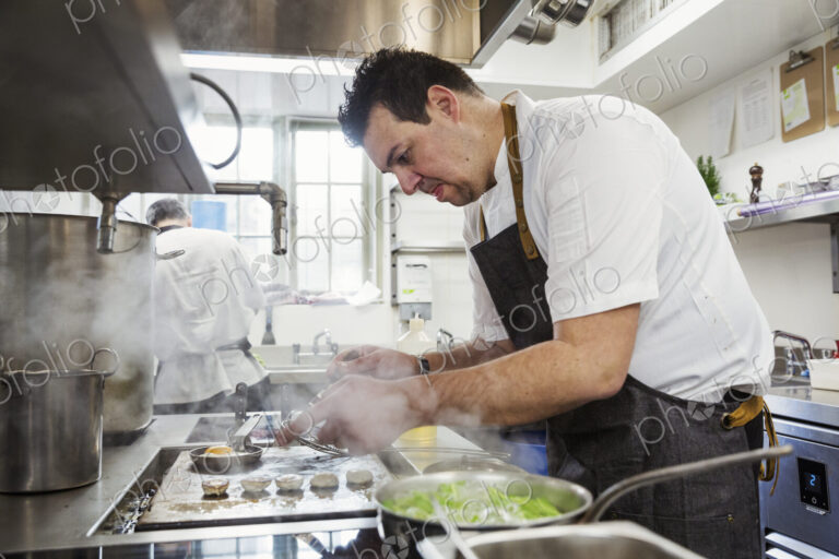 Chef cooking in the kitchen of a small boutique hotel.