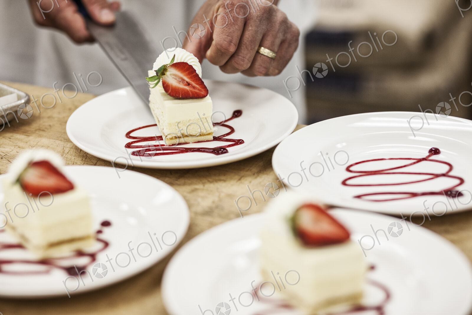 Chef hands placing a layered desert on a plate, presentation of a sweet dish.