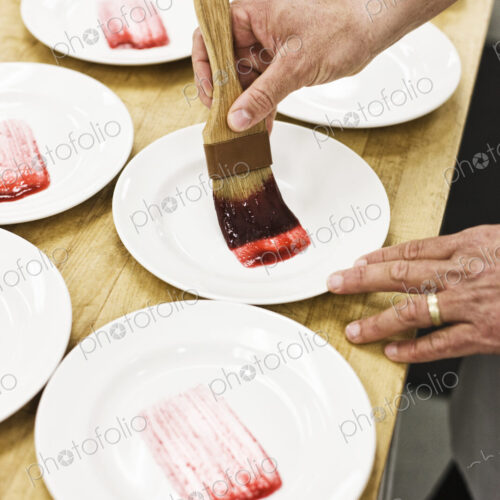 Chef hands preparing a desert plate.
