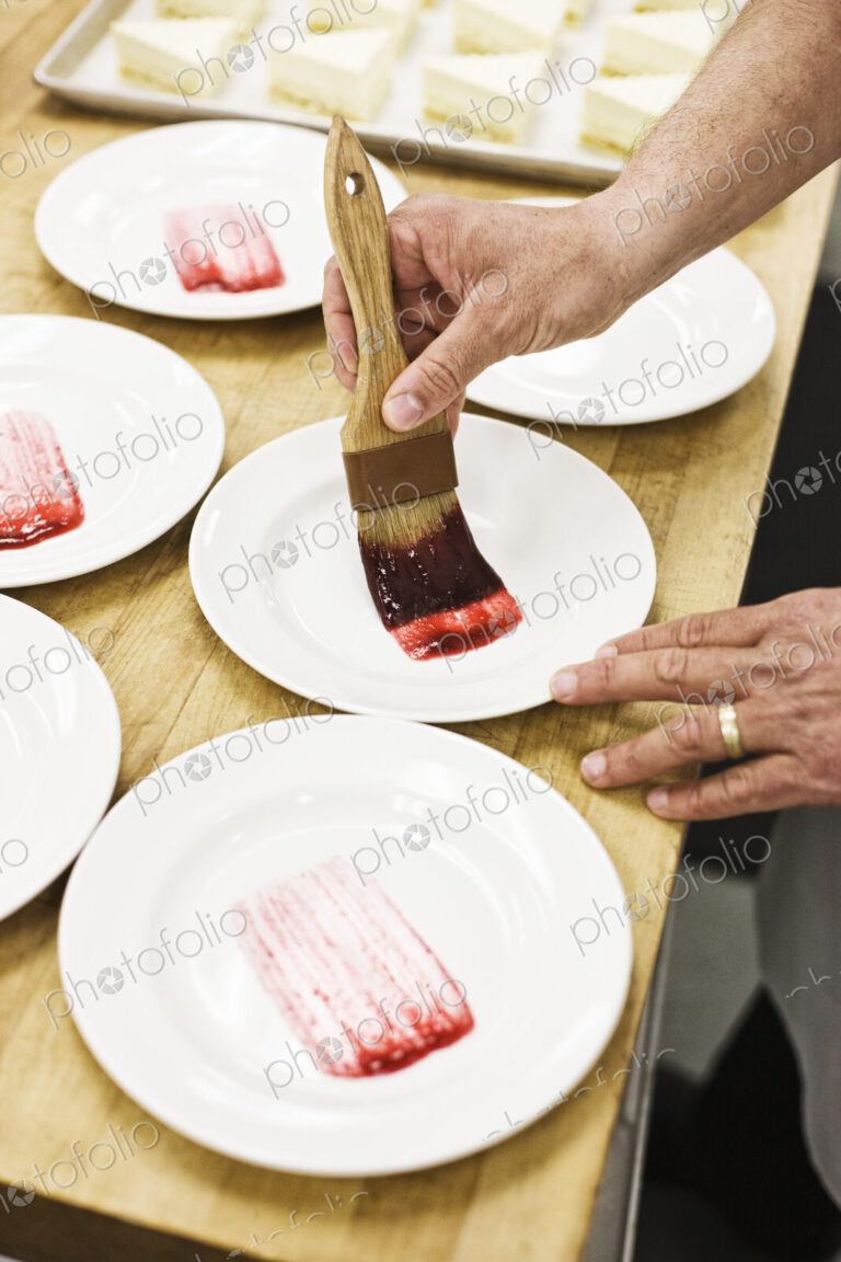 Chef hands preparing a desert plate.