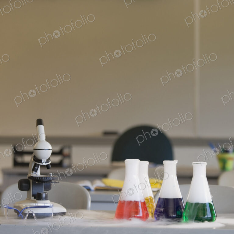 Chemistry equipment on laboratory bench, microscope and beakers.