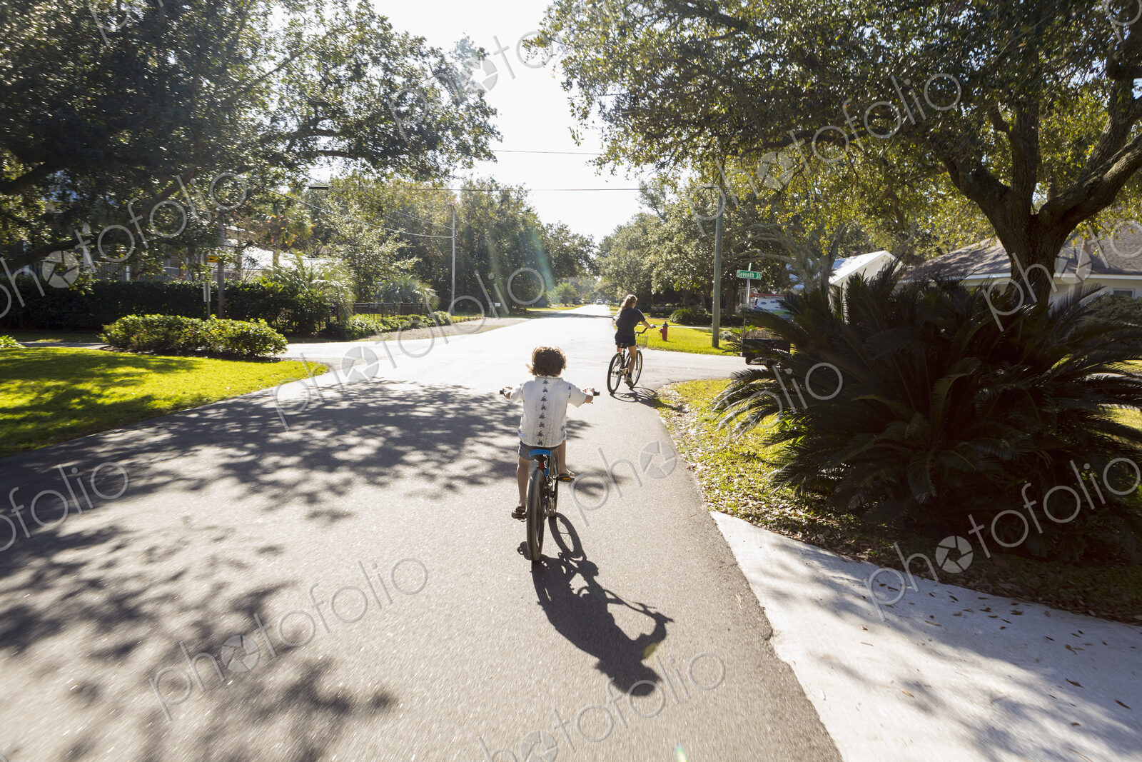 Children, a pre teenager and her brother cycling on a suburban road