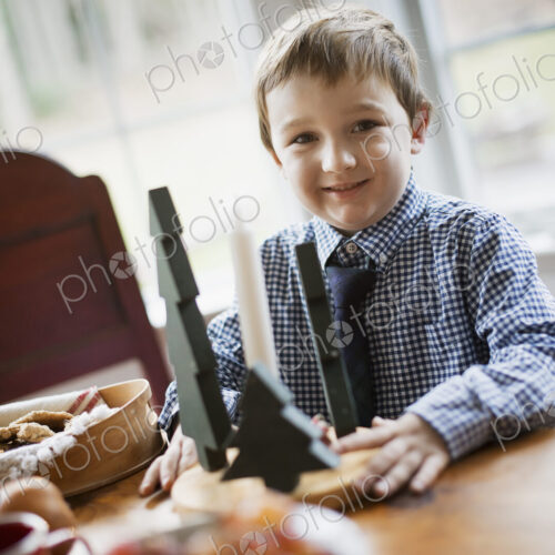 Children in a family home. A young boy at a table, beside a large tray of biscuits.… Children in a family home. A young boy at a table, beside a large tray of biscuits.…