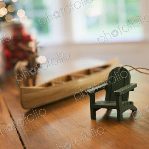 Christmas Decorations on a table. A handmade wooden canoe and a small chair.