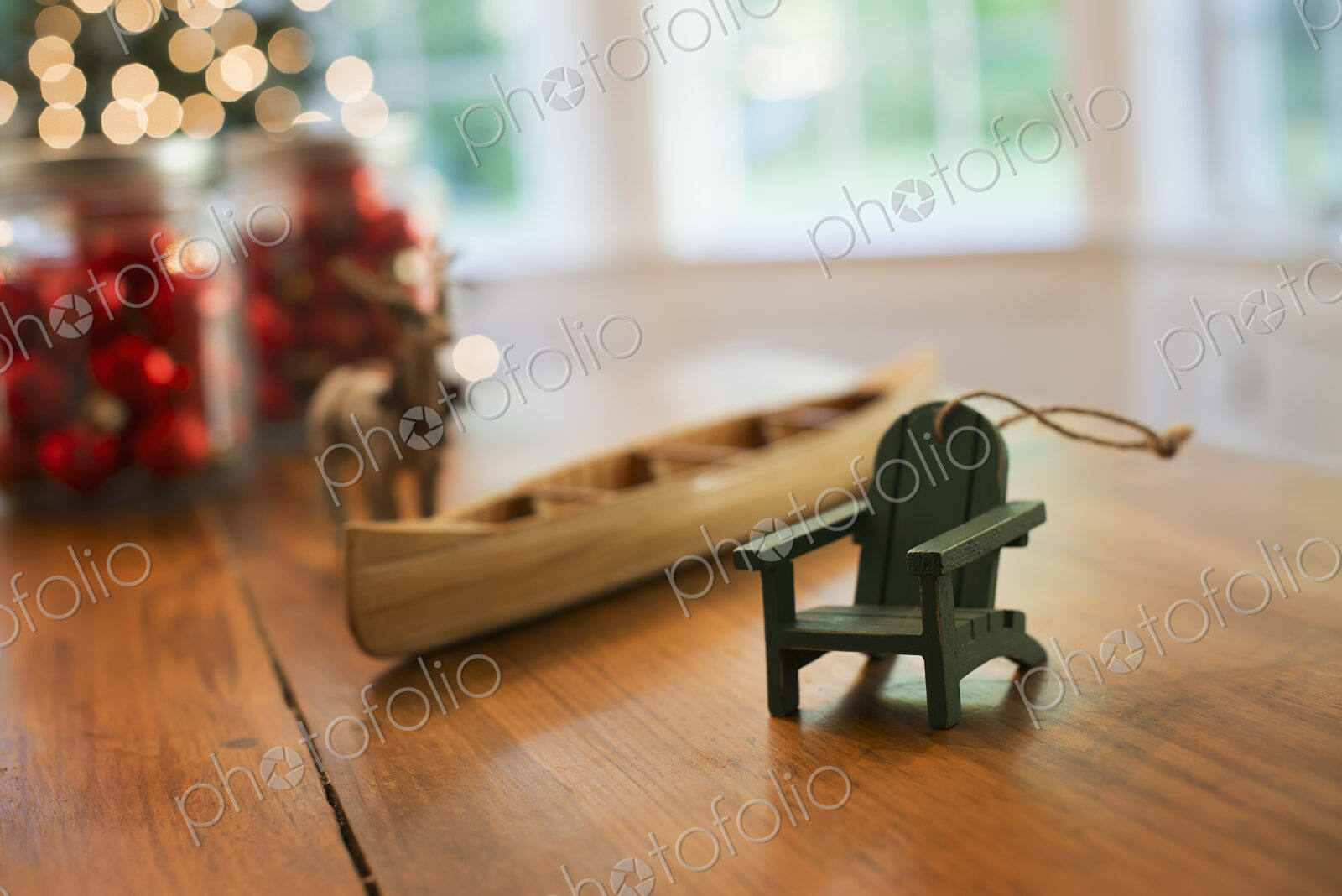 Christmas Decorations on a table. A handmade wooden canoe and a small chair.