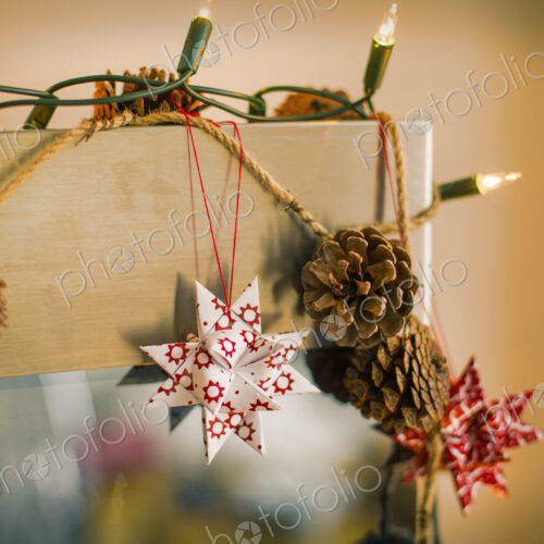Christmas decorations. Fairy lights, pine cones and paper stars. Christmas decorations. Fairy lights, pine cones and paper stars.