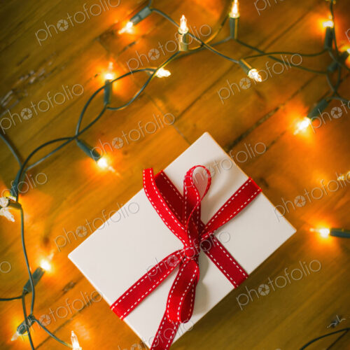 Christmas decorations. Gift box tied with a ribbon and fairy lights. Christmas decorations. Gift box tied with a ribbon and fairy lights.