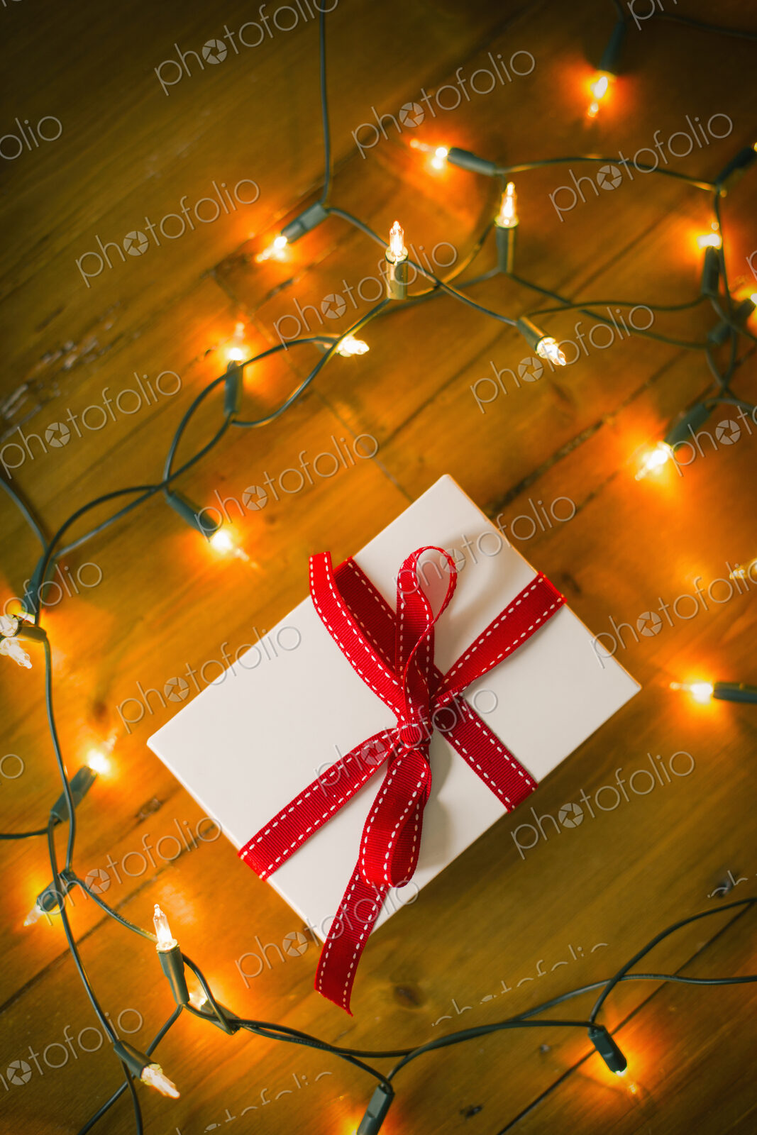 Christmas decorations. Gift box tied with a ribbon and fairy lights.