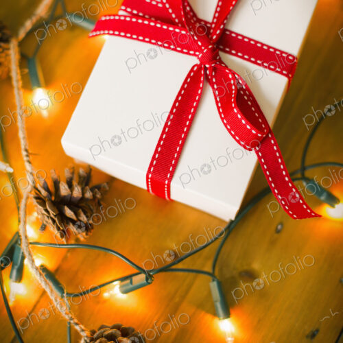Christmas decorations. Gift box tied with a ribbon and fairy lights. Christmas decorations. Gift box tied with a ribbon and fairy lights.