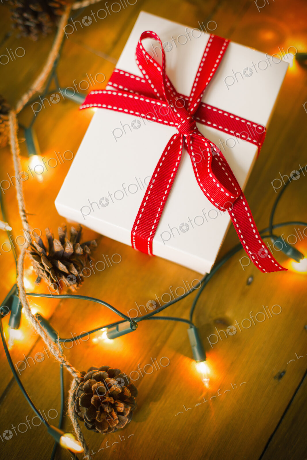 Christmas decorations. Gift box tied with a ribbon and fairy lights.