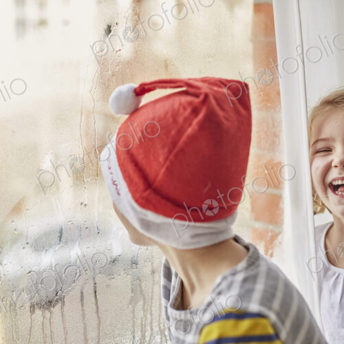 Christmas morning in a family home, two children laughing Christmas morning in a family home, two children laughing