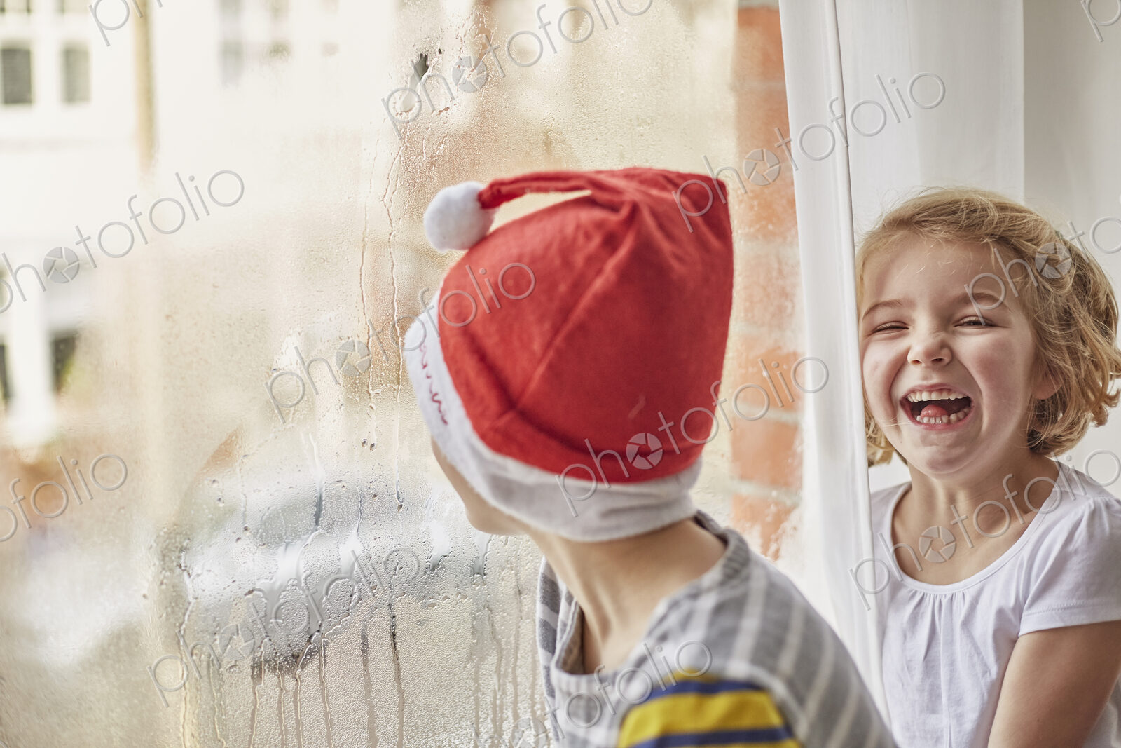 Christmas morning in a family home, two children laughing