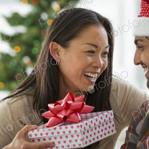 Christmas time. Celebrating the holidays. A man in a Father Christmas hat. At home. A… Christmas time. Celebrating the holidays. A man in a Father Christmas hat. At home. A…