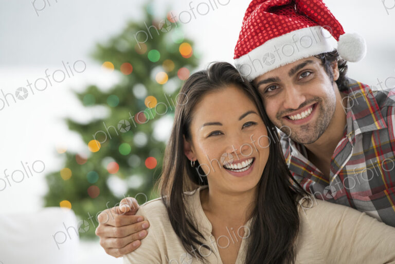 Christmas time. Celebrating the holidays. A man in a Father Christmas hat. At home. A…