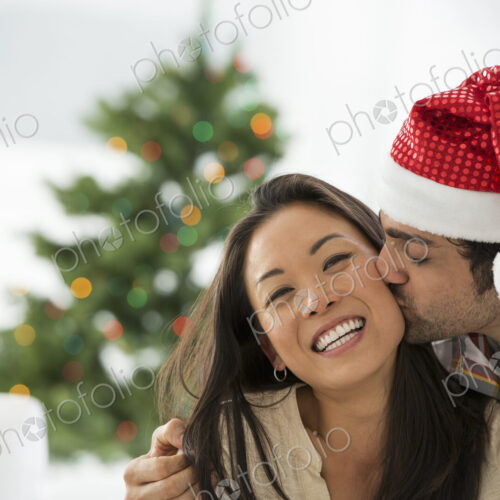 Christmas time. Celebrating the holidays. A man in a Father Christmas hat. At home. A… Christmas time. Celebrating the holidays. A man in a Father Christmas hat. At home. A…