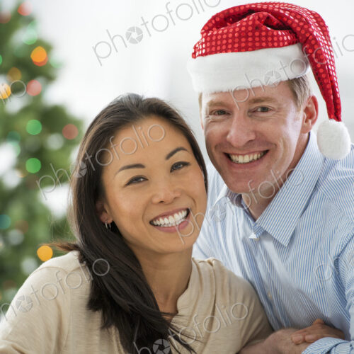 Christmas time. Celebrating the holidays. A man in a Father Christmas hat. At home. A… Christmas time. Celebrating the holidays. A man in a Father Christmas hat. At home. A…