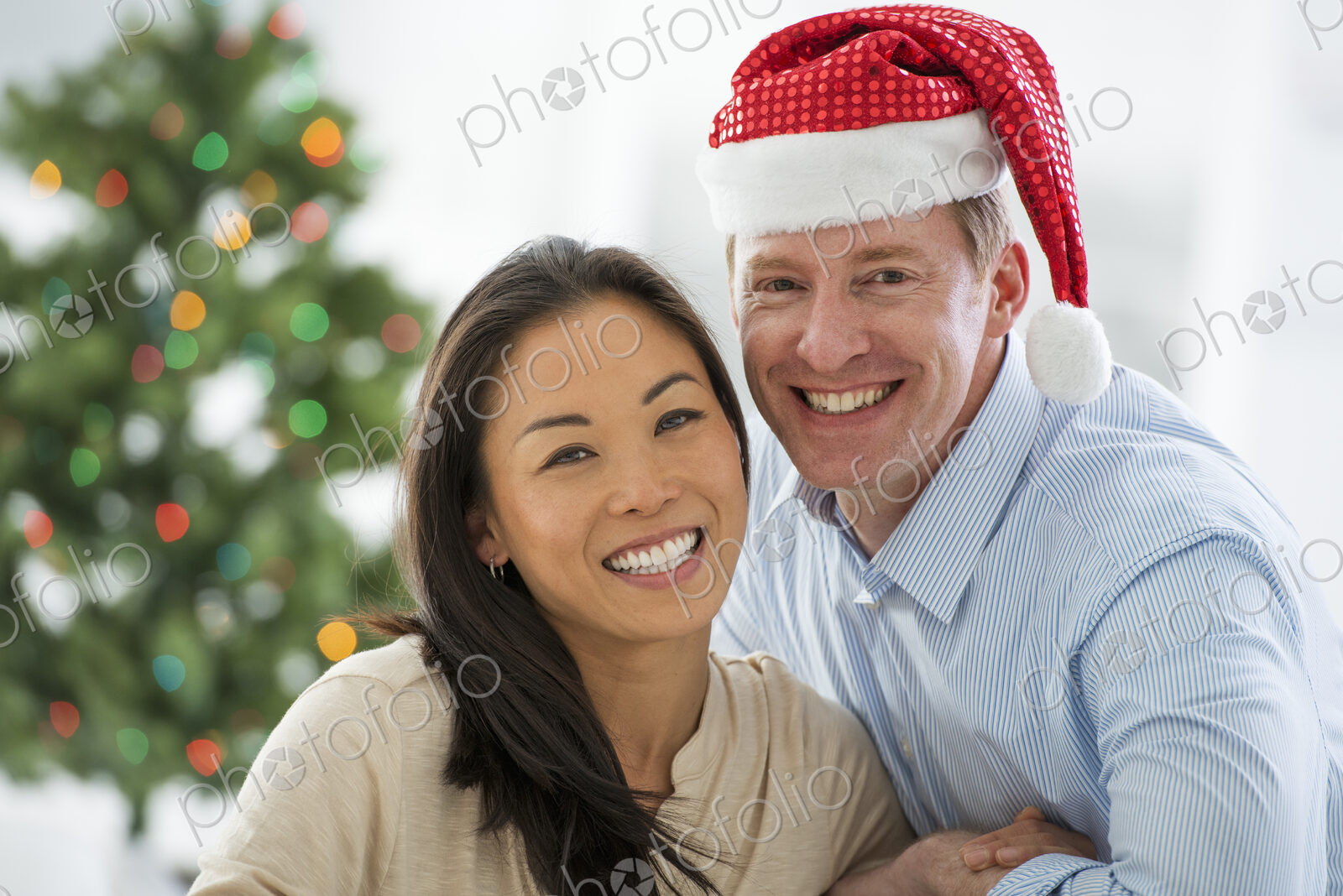 Christmas time. Celebrating the holidays. A man in a Father Christmas hat. At home. A…