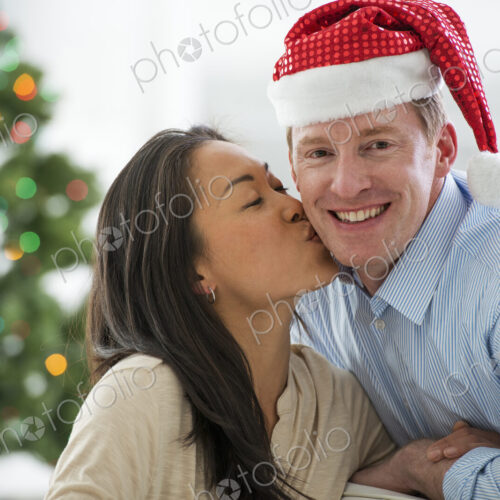 Christmas time. Celebrating the holidays. A man in a Father Christmas hat. At home. A… Christmas time. Celebrating the holidays. A man in a Father Christmas hat. At home. A…