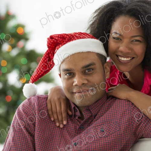 Christmas time. Celebrating the holidays. A man in a Father Christmas hat. At home. A… Christmas time. Celebrating the holidays. A man in a Father Christmas hat. At home. A…