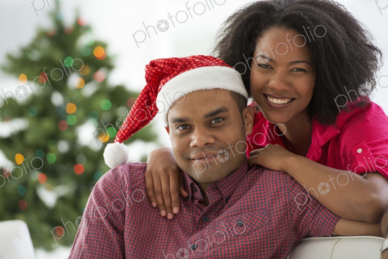 Christmas time. Celebrating the holidays. A man in a Father Christmas hat. At home. A…