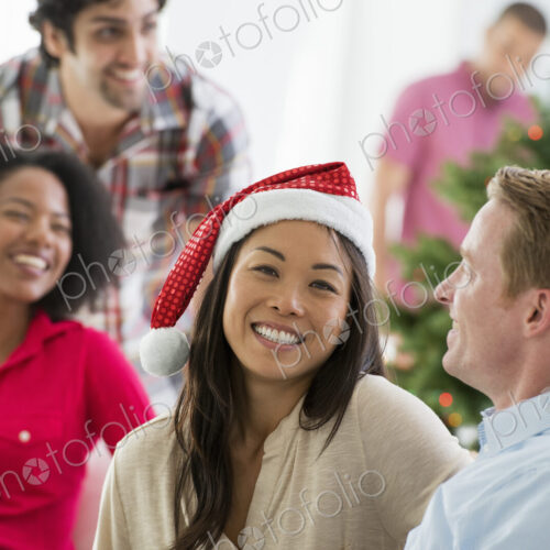 Christmas time. Celebrating the holidays. A woman wearing a red and white Father… Christmas time. Celebrating the holidays. A woman wearing a red and white Father…