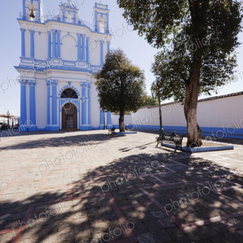 Church in a town square and a shady bench under a tree Church in a town square and a shady bench under a tree
