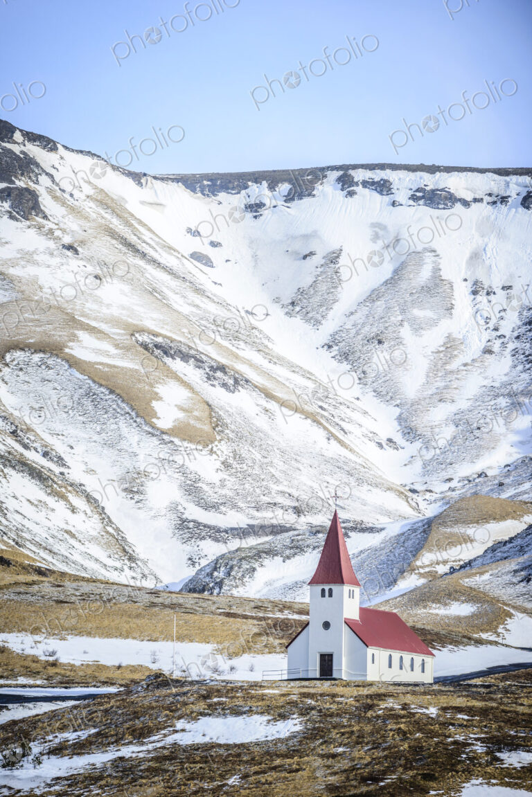 Church under snowy mountains in rural landscape