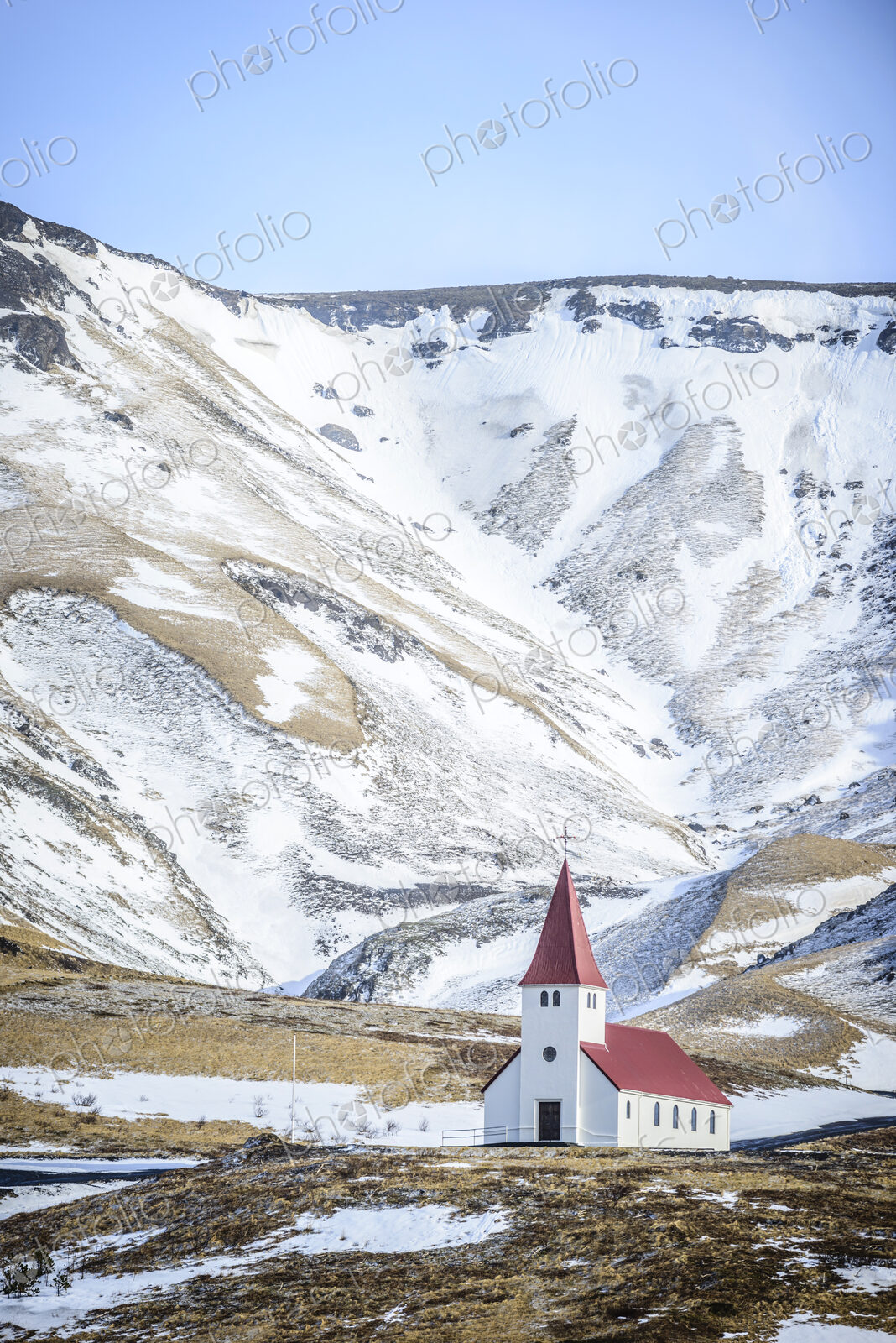 Church under snowy mountains in rural landscape