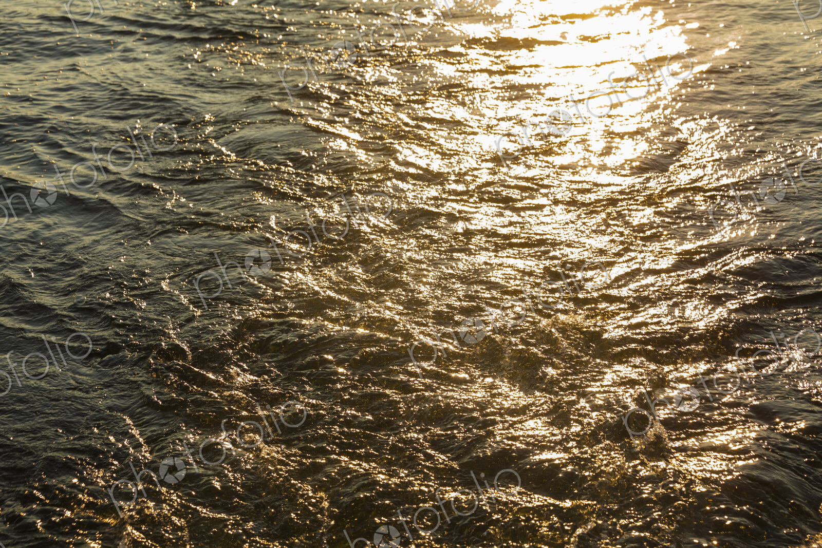 Churned up water with the sun reflecting off the surface.