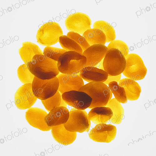 Circular pile of organic apricots on white background