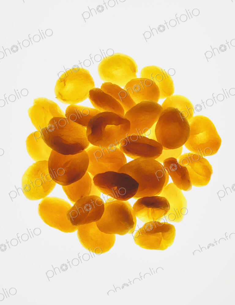 Circular pile of organic apricots on white background