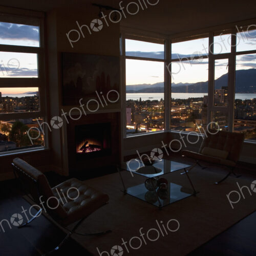 City at night through windows of open plan apartment. City at night through windows of open plan apartment.