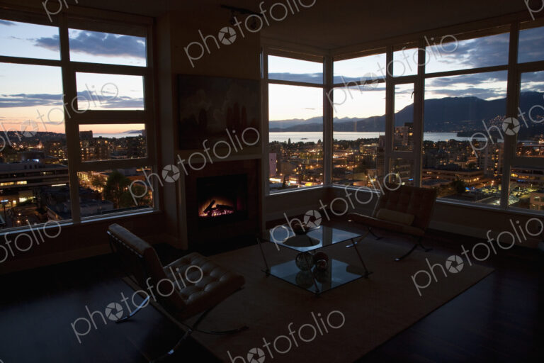 City at night through windows of open plan apartment.