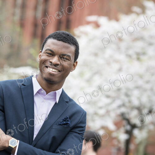 City life in spring. A man in a blue suit with arms folded, in a city park. City life in spring. A man in a blue suit with arms folded, in a city park.