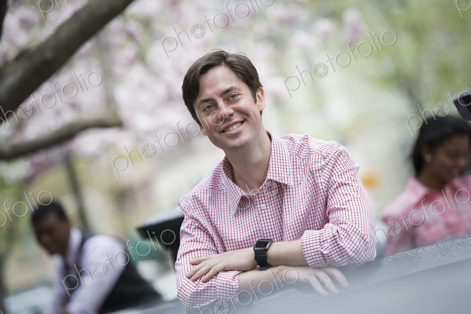 City life in spring. A man sitting outdoors in a city park. Looking at the camera and…