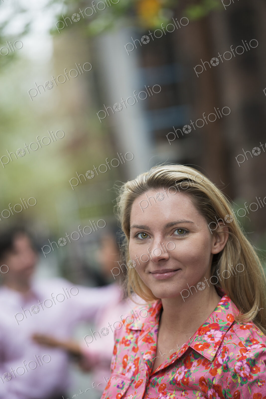 City life in spring. A woman with long blonde hair looking at the camera.